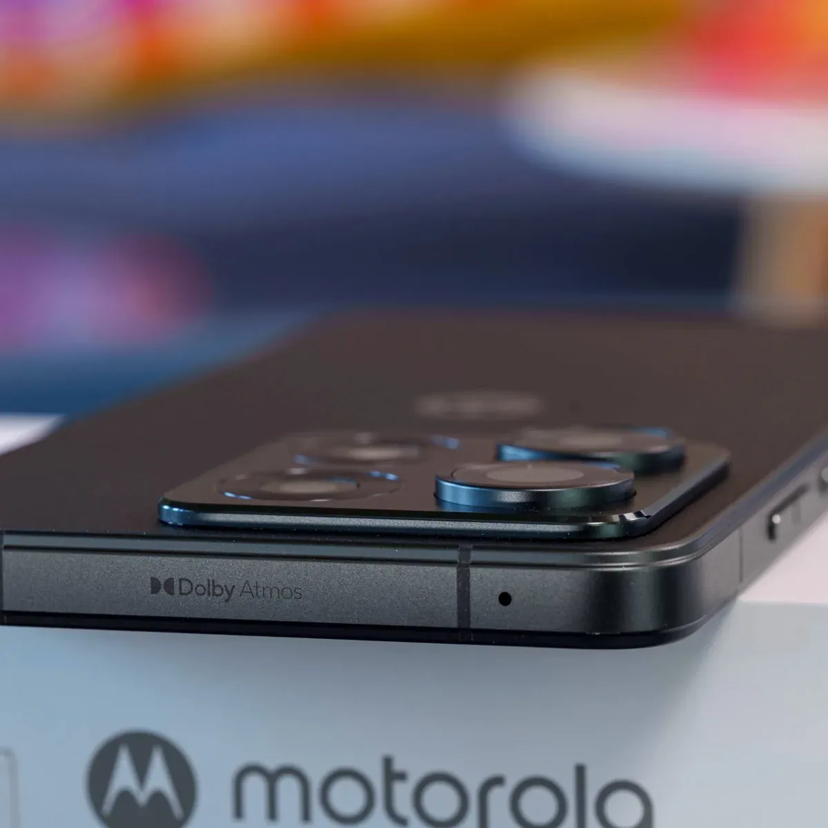 PhonesGate close-up studio photo of the Moto G86 side profile with Dolby Atmos branding