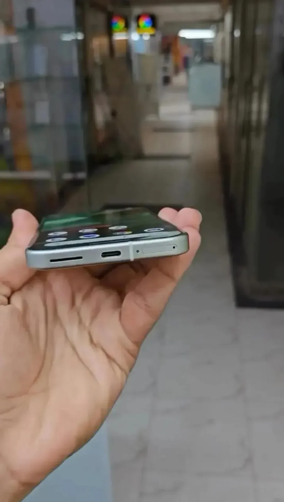 Google Pixel 10a bottom edge showing the flat frame, USB-C port, speaker and SIM tray